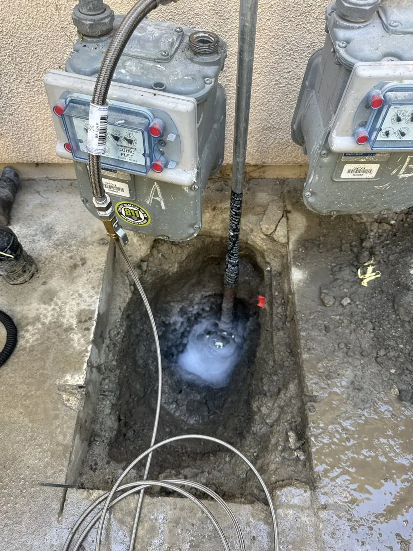 Excavated piping beside utility equipment